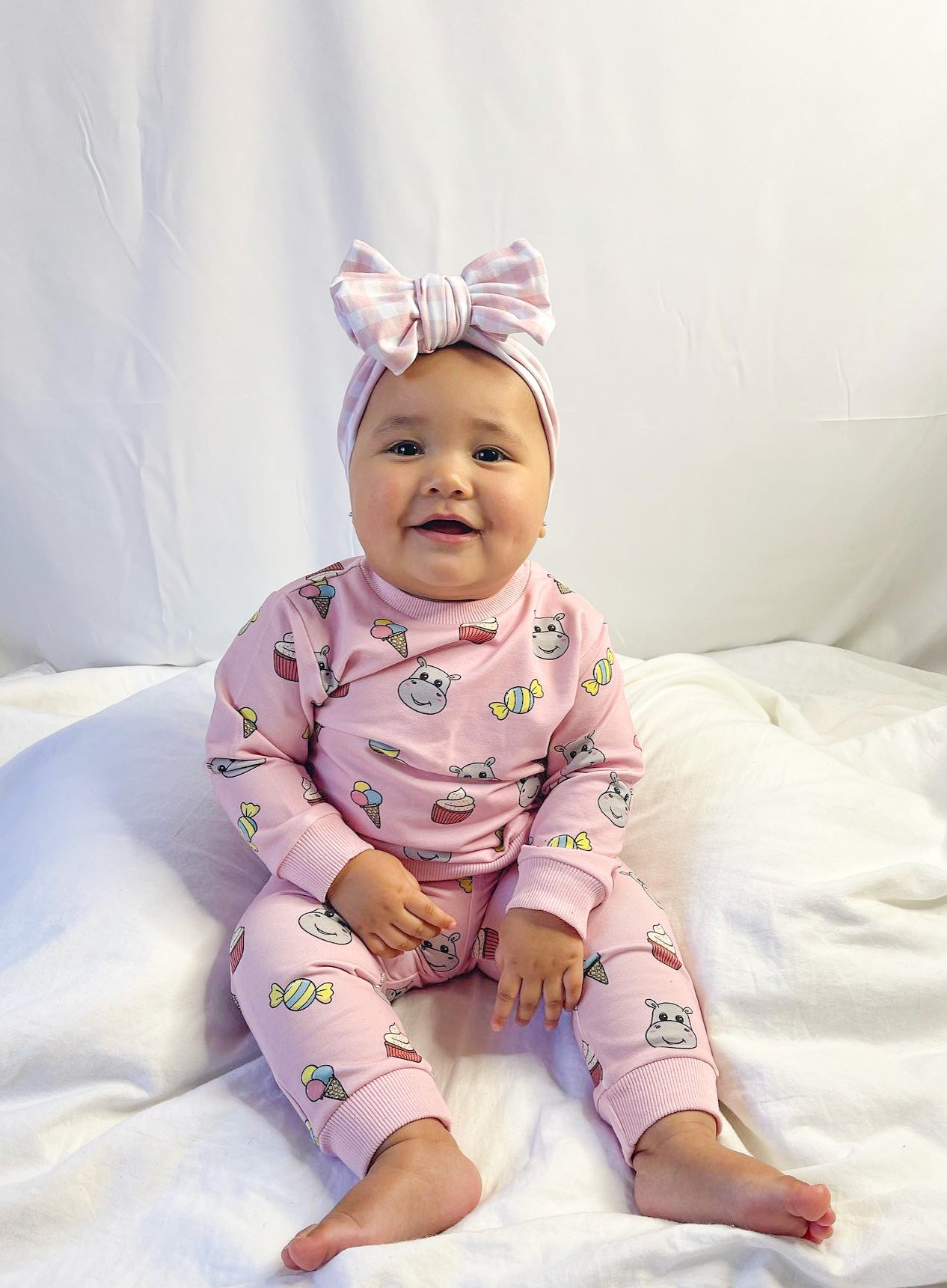 baby girl wearing hungry hippo baby lounge set in pastel pink with our exclusive candy print
