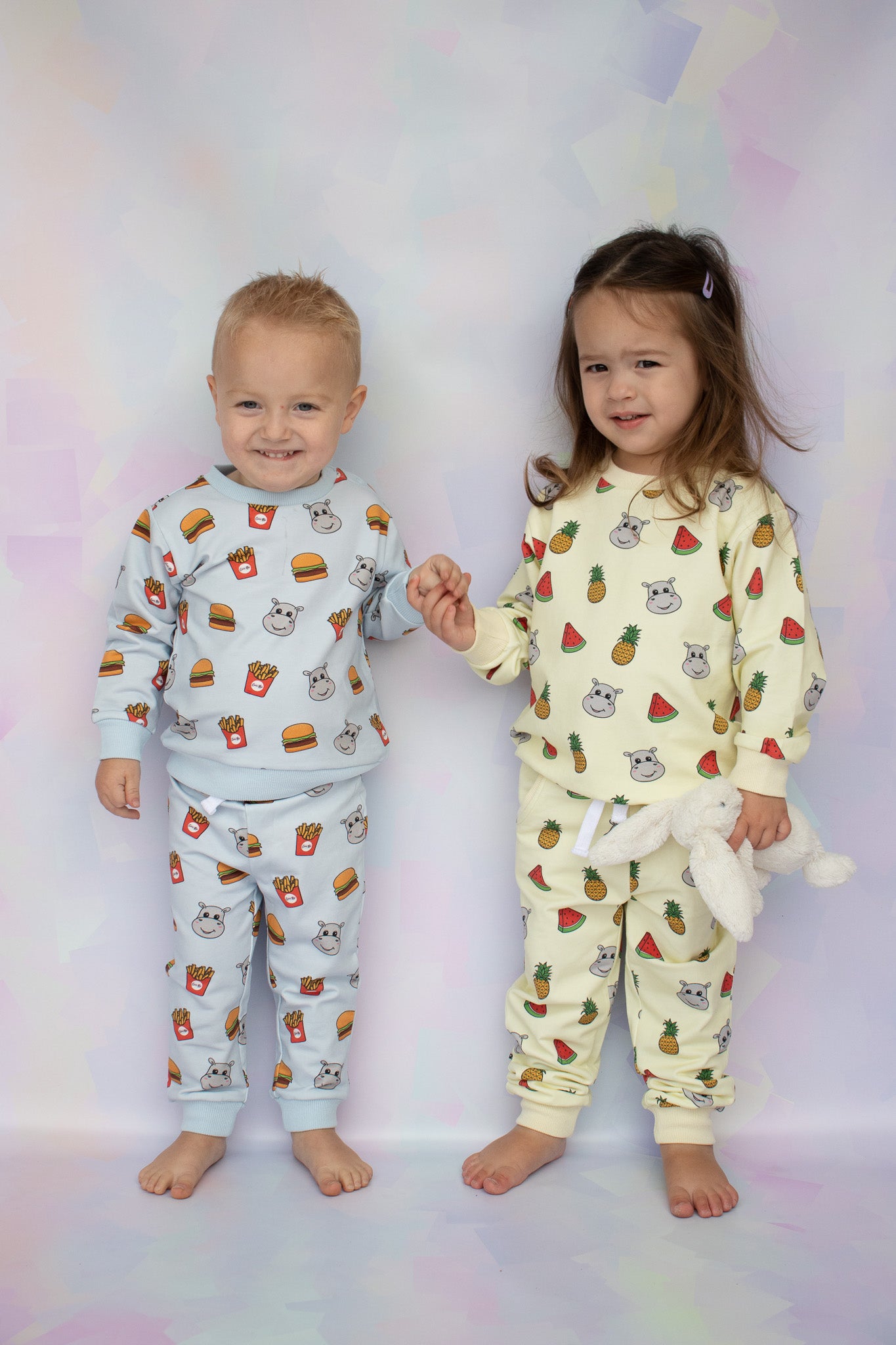 boy toddler wearing burger and fries hippo print lounge set and toddler girl wearing watermelon and pineapple hungry hippo lounge sets
