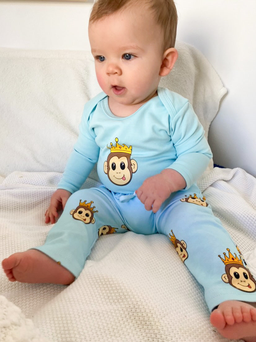 cute baby wearing a blue long sleeve romper with a monkey design