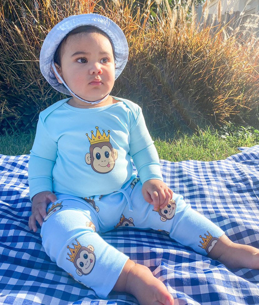 baby wearing a blue long sleeve romper with a cute monkey design and blue pants