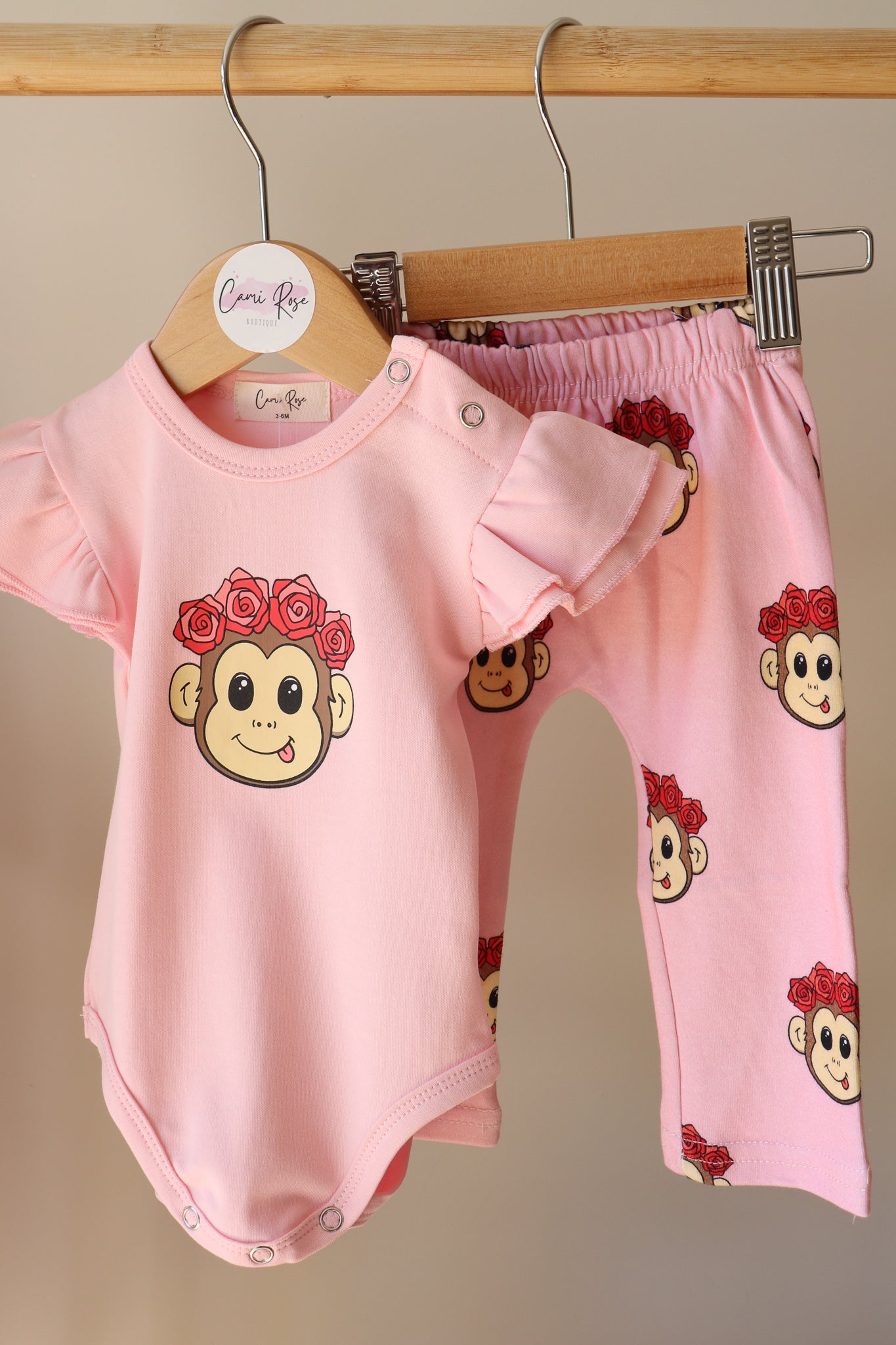 baby pink frill romper with a cute monkey design