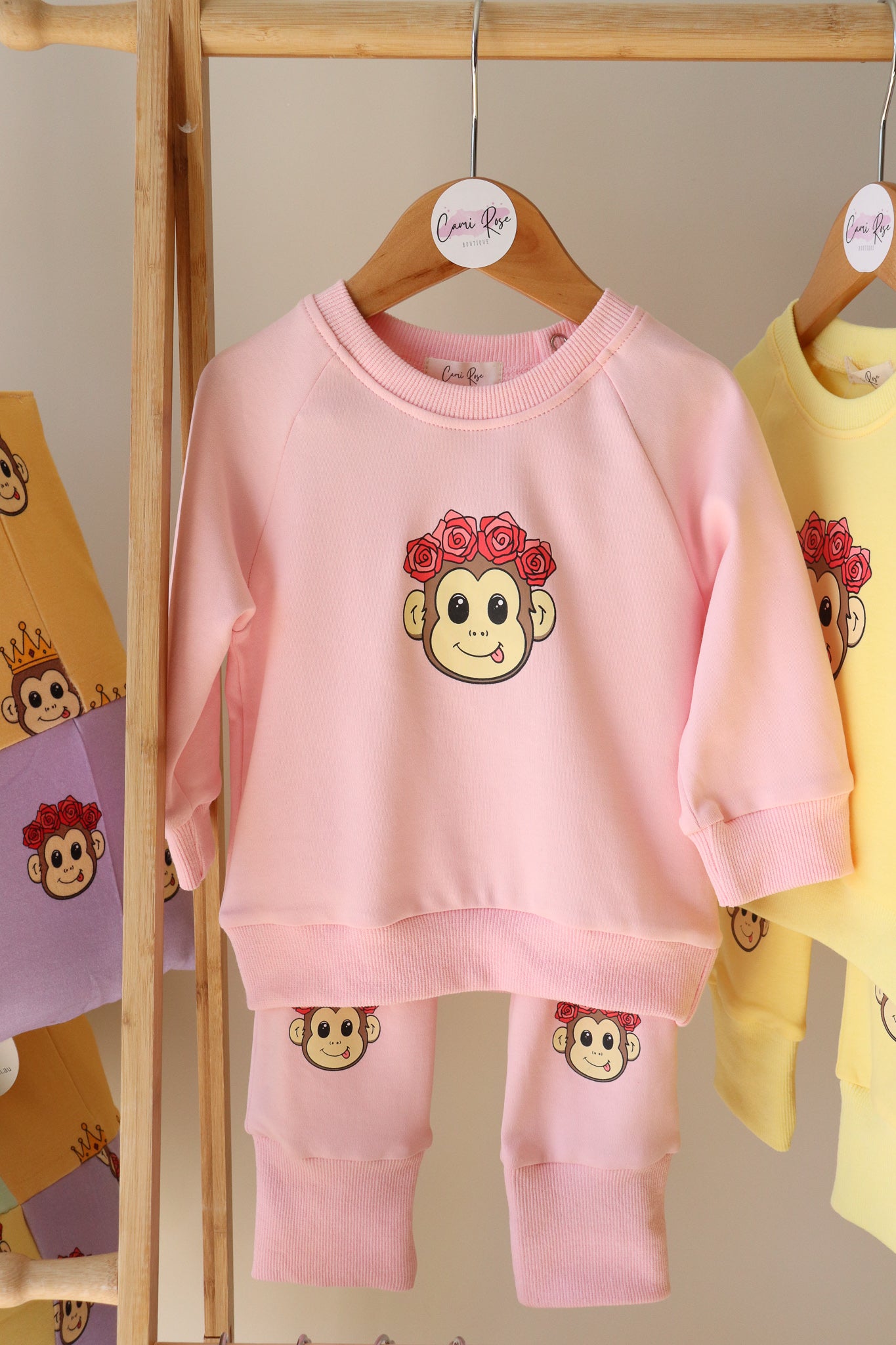 baby pink lounge set with a cute monkey design printed on the jumper and on the knees of the pants